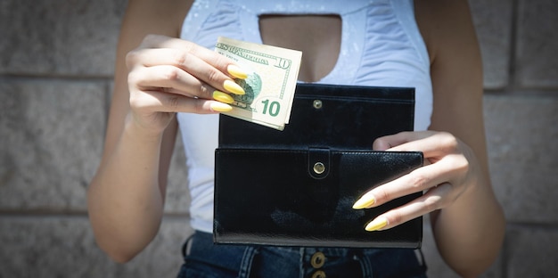 Mains de femme avec portefeuille et argent