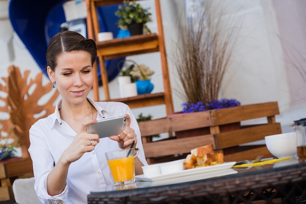 Mains de femme prenant la photo alimentaire par téléphone mobile. Photographie culinaire. Délicieux petit déjeuner.