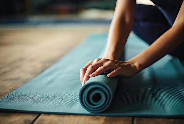 les mains d'une femme ramassant un tapis de yoga vert dans le style de tonification divisée