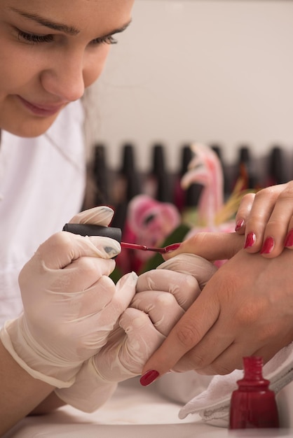 Mains de femme recevant une manucure dans un salon de beauté. Limage des ongles. Gros plan, mise au point sélective.