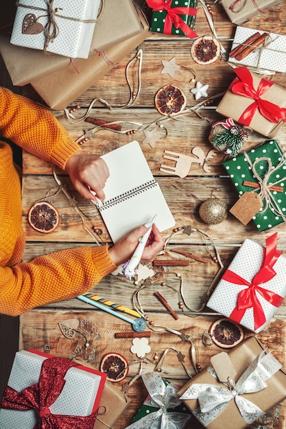 Photo mains de femme avec un stylo et un bloc-notes pour écrire une lettre au père noël