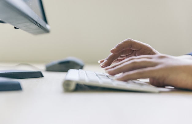 Mains de femme tapant sur le clavier de l'ordinateur