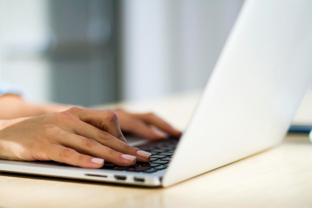 Mains de femme tapant sur un concept de travail d'ordinateur portable