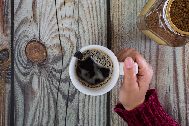 Mains de femme avec une tasse de café