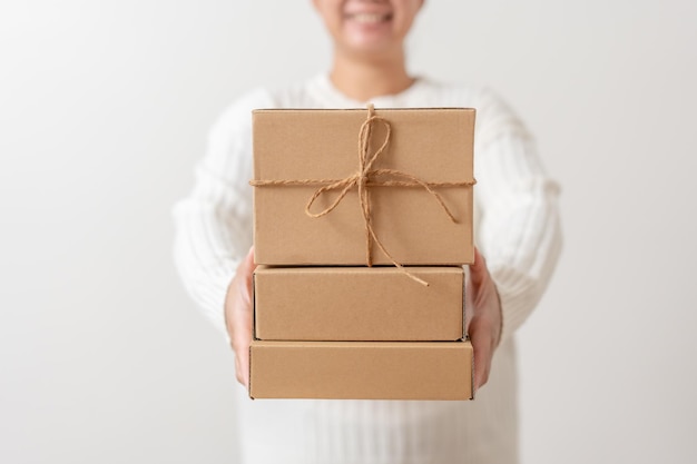 Mains de femme tenant une boîte cadeau avec un noeud de ruban Concept de style minimaliste de boîte cadeau