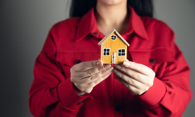 Mains de femme tenant une maison modèle