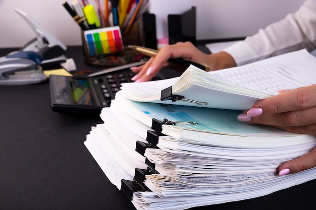 Mains de femme tenant une pile de documents