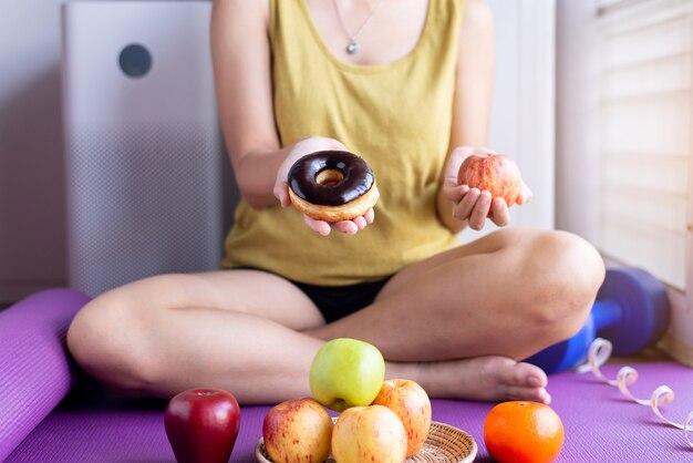 Mains De Femme Tenant Une Pomme Rouge Et Un Beignet Au Chocolat Cuit Au Four à La Maison, Alimentation Saine, Concept De Régime