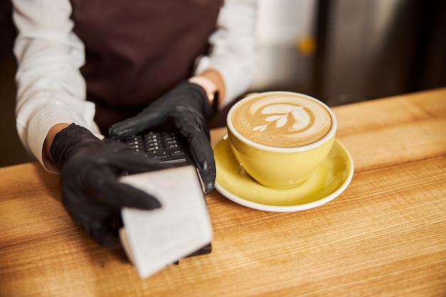 Mains de femme tenant le reçu de paiement sur la table