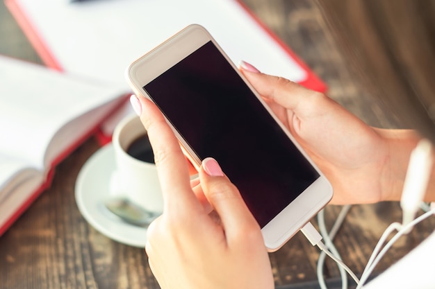 Mains de femme tenant le smartphone.