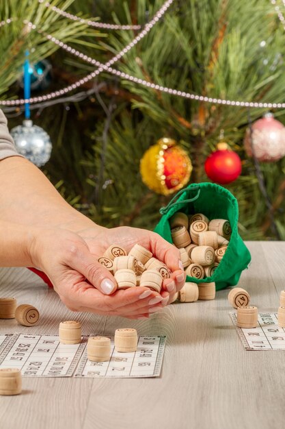 Mains de femme tenant des tonneaux en bois pour un jeu de loto