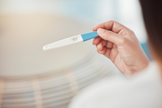 Mains de femme et test de grossesse avec informations sur les résultats négatifs et lignes à la maison