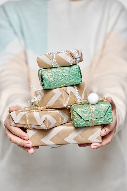 Les mains de la femme tiennent des boîtes-cadeaux. Boîte cadeau décorée pour Noël ou le nouvel an.