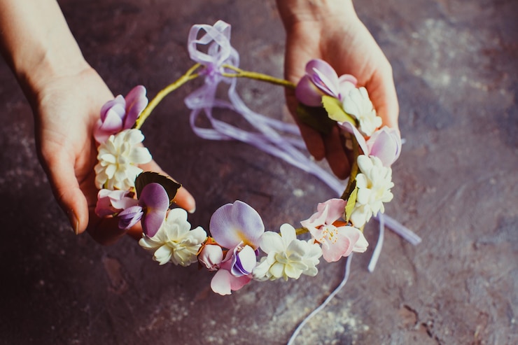 Photo les mains de la femme tiennent une couronne de mousse avec des fleurs de sprint. accessoire de mode pour la coiffure