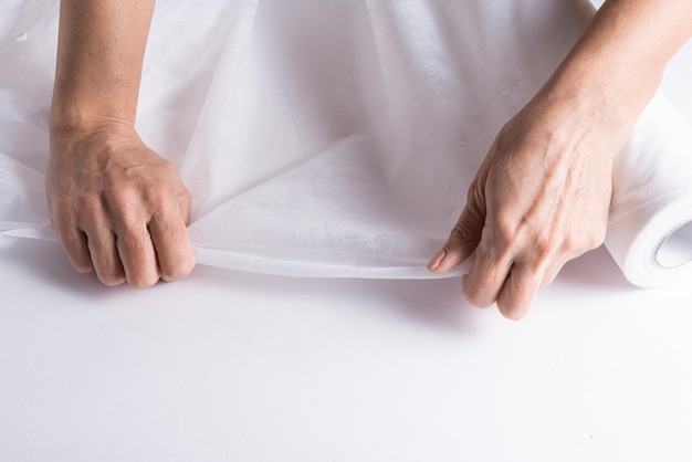 Mains de femme travaillant avec un rouleau de couverture pour lit médical