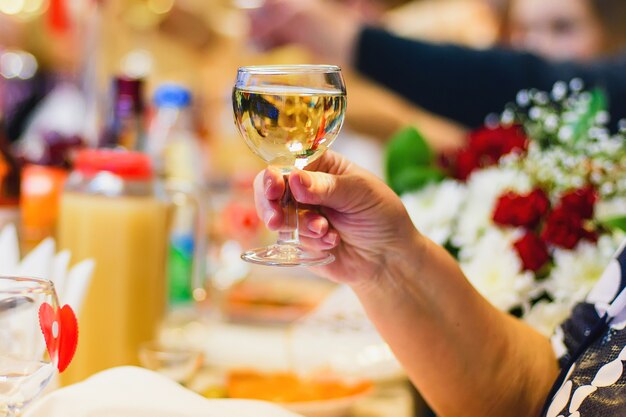 Mains d'une femme avec un verre de vin blanc