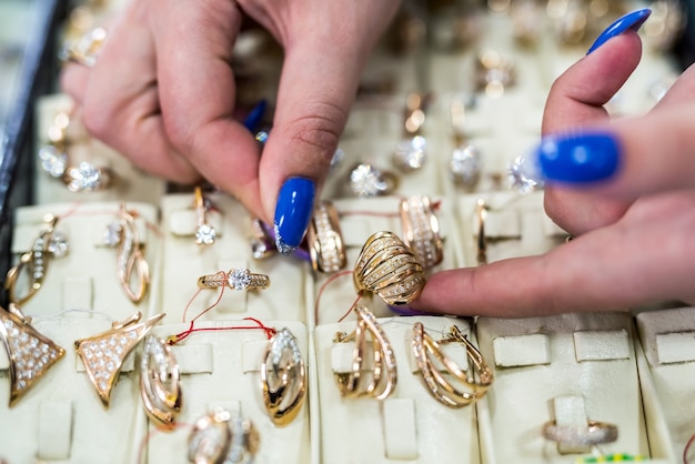 Les mains des femmes avec des bijoux en or se bouchent