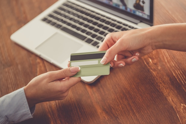 mains de femmes détenant une carte de crédit