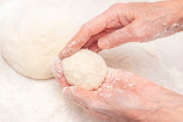 Mains de femmes, farine et pâte.