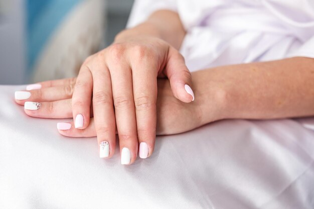 Les mains des femmes jointes sur leurs genoux en prévision du mariage et du marié