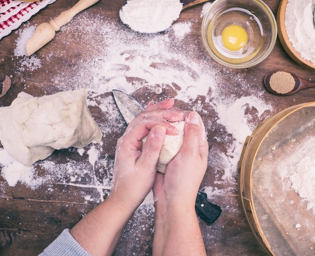 Les mains des femmes mélangent la pâte de levure à partir de farine de blé blanche