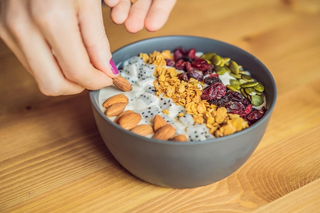 Les mains des femmes préparent un bol de smoothie