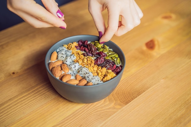 Les mains des femmes préparent un bol de smoothie