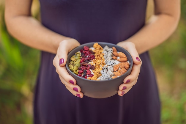 Les mains des femmes préparent un bol de smoothie