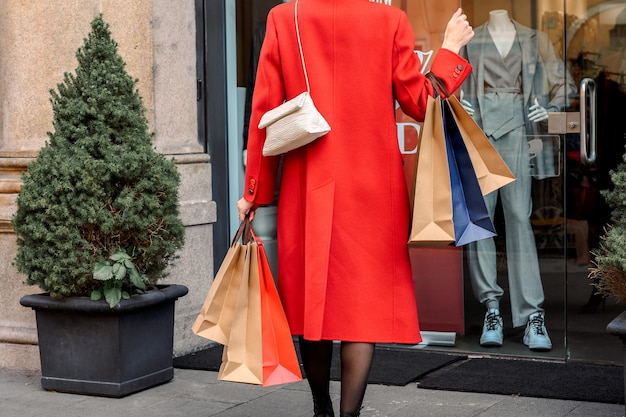 Les mains des femmes de la saison des soldes tiennent de nombreux sacs à provisions