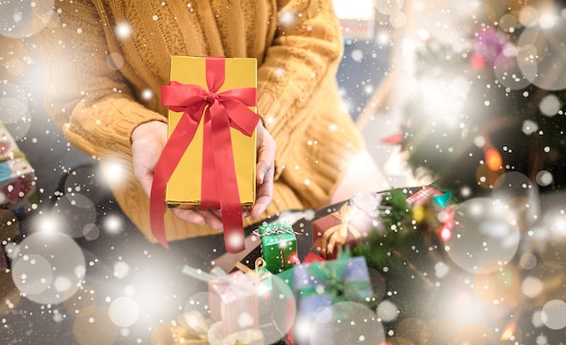 Mains de femmes tenant une boîte-cadeau Cadeaux colorés pour les anniversaires Boîtes avec fond noué et bokeh