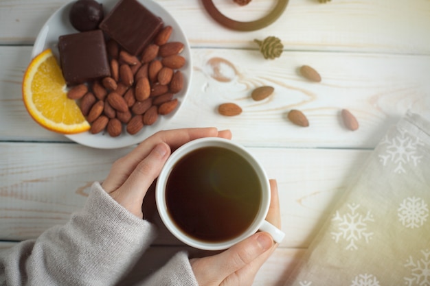 Mains de femmes tenant une tasse de café.