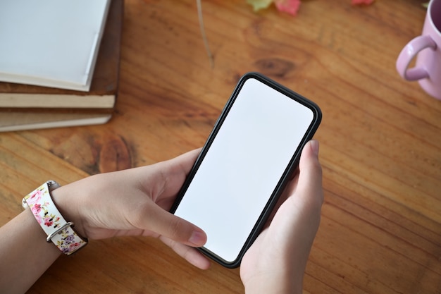 mains de femmes tenant un téléphone portable avec un écran blanc pour montage d&#39;affichage graphique.