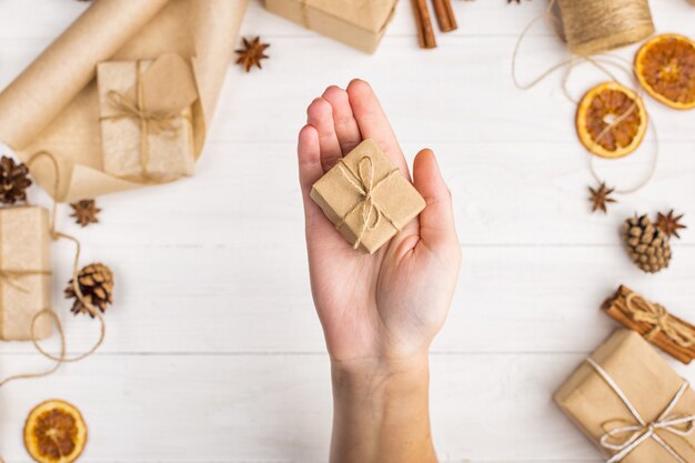 Les mains des femmes tiennent un cadeau de papier kraft.