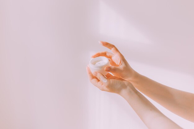 Les mains des femmes tiennent une crème d'espace de copie cosmétique Un article sur les cosmétiques de soin Crème pour les mains