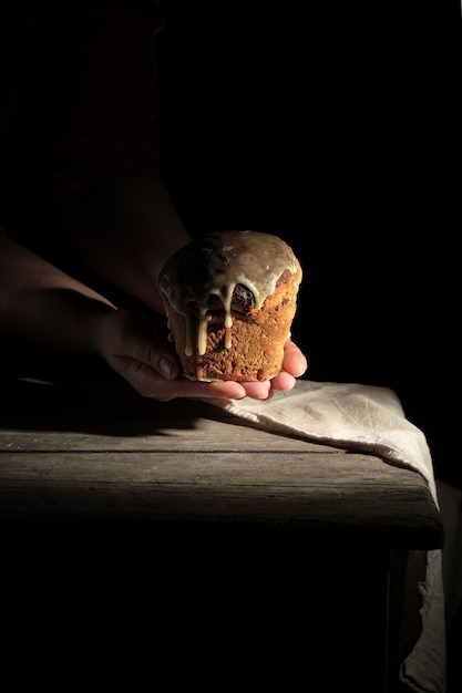 Des mains de femmes tiennent une pâtisserie traditionnelle cuite au four pour Pâques