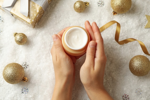 Les mains des femmes tiennent un pot de crème cosmétique