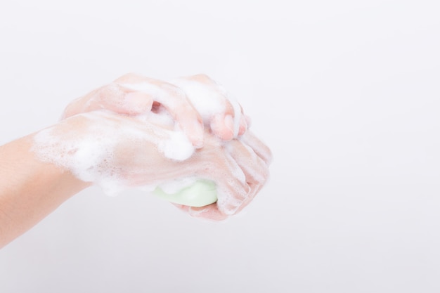 Les mains de la fille asiatique se lavent avec des bulles de savon.