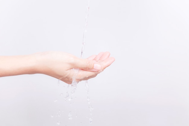 Les mains de la fille asiatique sont éclaboussées avec de l&#39;eau sur fond blanc