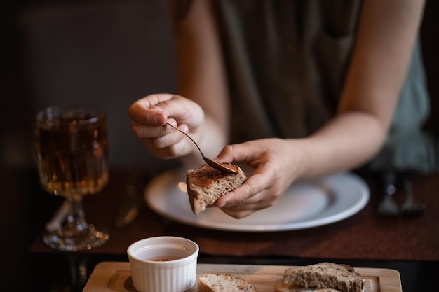 Les mains de la fille étalées sur la sauce au pain