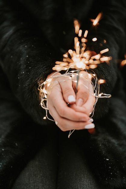 Mains d'une fille avec un gros plan de sparkler