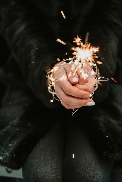 Mains d'une fille avec un gros plan de sparkler