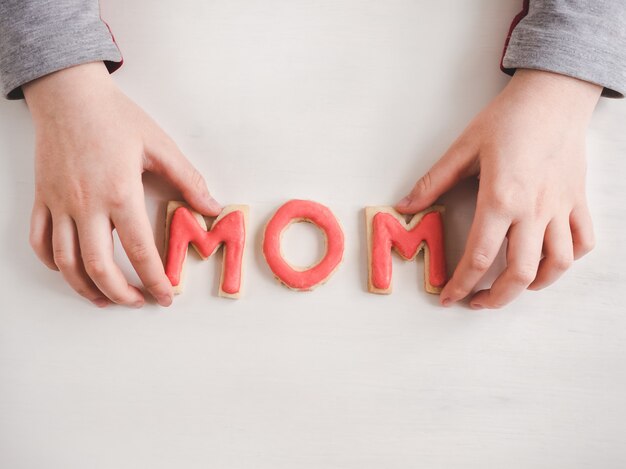 Mains d&#39;une fille plus jeune et mot MOM