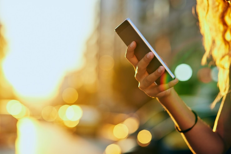 Photo mains de fille et ville avec téléphone pour la communication sur les médias sociaux ou le réseau sur fond bokeh vue rapprochée d'une personne féminine ou d'un utilisateur sur un smartphone mobile pour la navigation en ligne, le chat ou les sms en ville