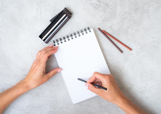 Mains de filles dessinant dans un cahier sur une table