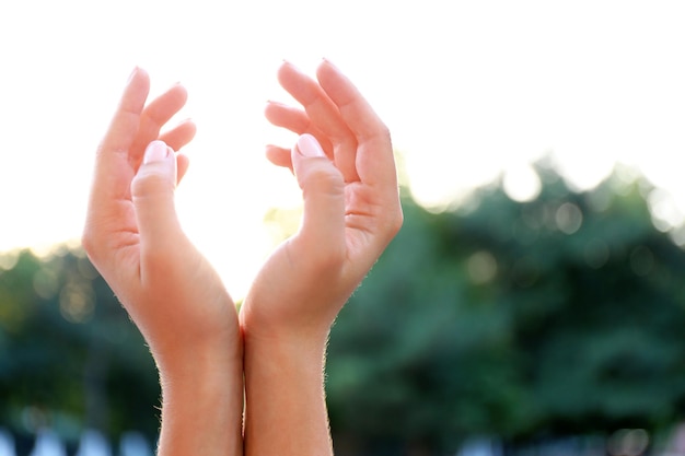 Photo les mains sur le fond de la lumière du soleil