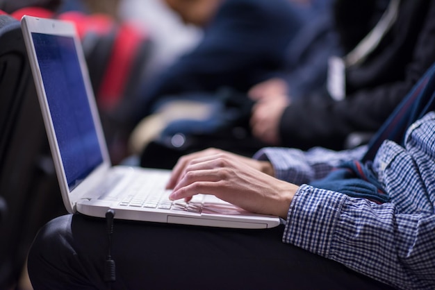 mains de gens d'affaires tapant sur le clavier d'un ordinateur portable pendant le séminaire dans la salle de conférence