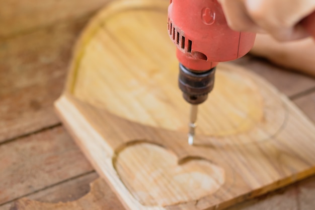 Photo les mains des gens à l'aide de la perceuse travaillant sur le bois