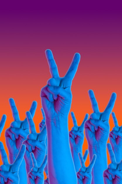 Photo mains de geste de victoire dans un style surréaliste dans des couleurs néon orange bleu violet. élément créatif psychédélique moderne avec paume humaine pour affiches, bannières, papier peint. modèle de style magazine. copiez l'espace.