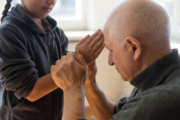 Mains de grand-père et petite-fille avec prière