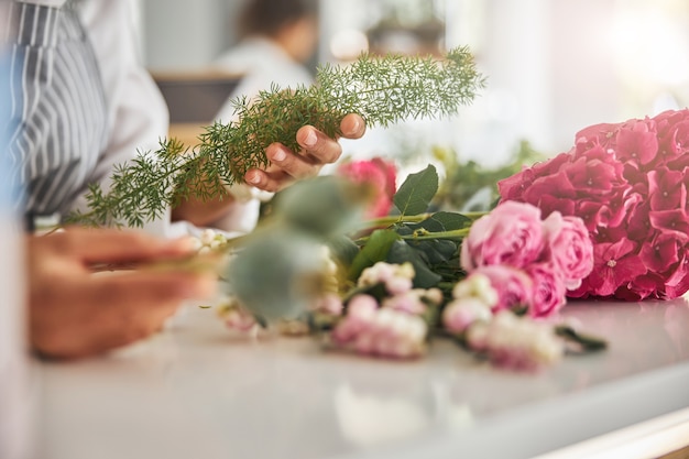 Mains habiles d'un fleuriste tenant une plante délicate